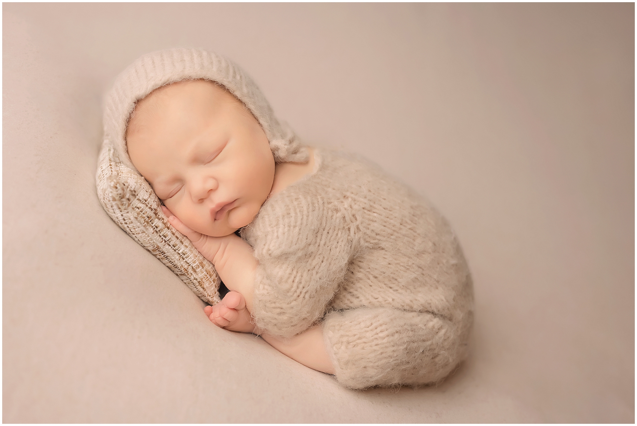 newborn baby posing on little pillow