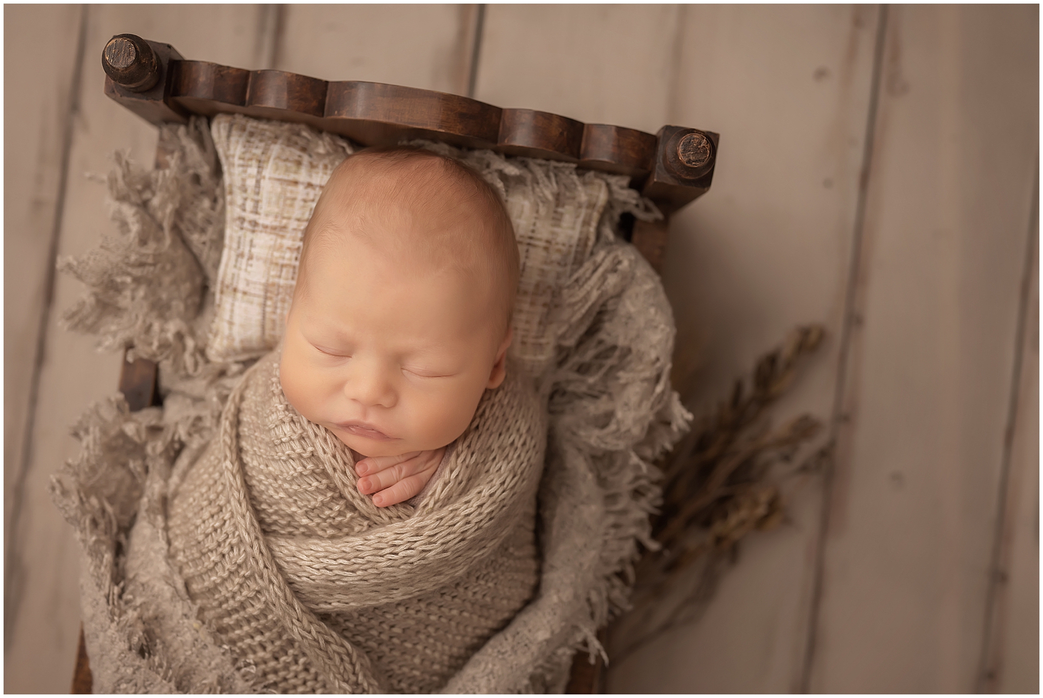 newborn baby sleeping in tiny bed during newborn photo session 