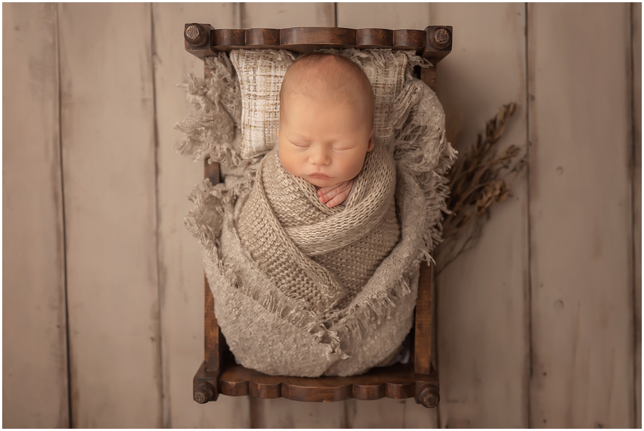 newborn baby wrapped in tiny bed for baby photo session 