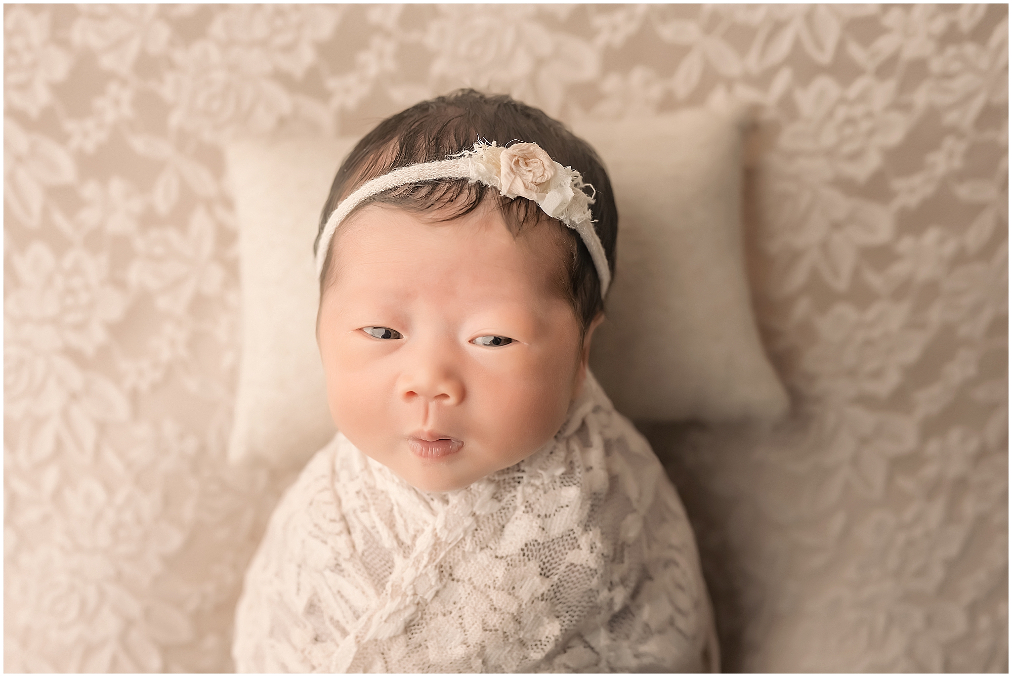 newborn baby with eyes open looking at the camera during newborn session in london ontario