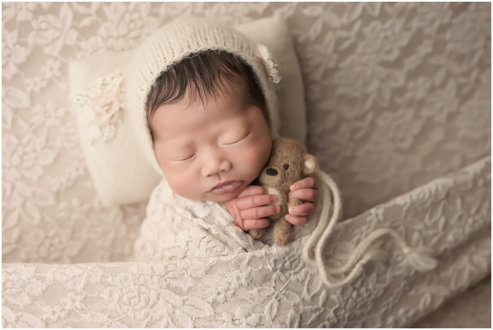 newborn baby holding teddy bear during newborn session in london ontario
