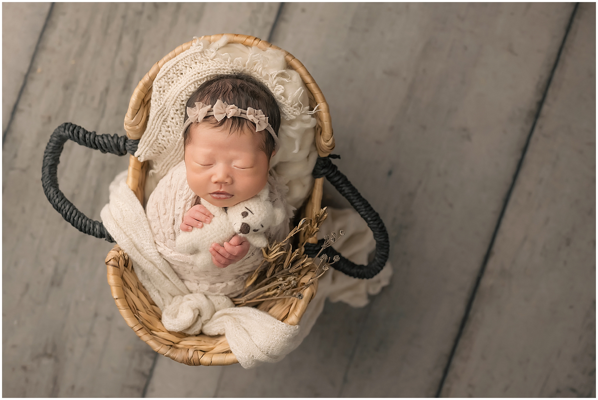 newborn baby holding bear in basket during newborn session in london ontario
