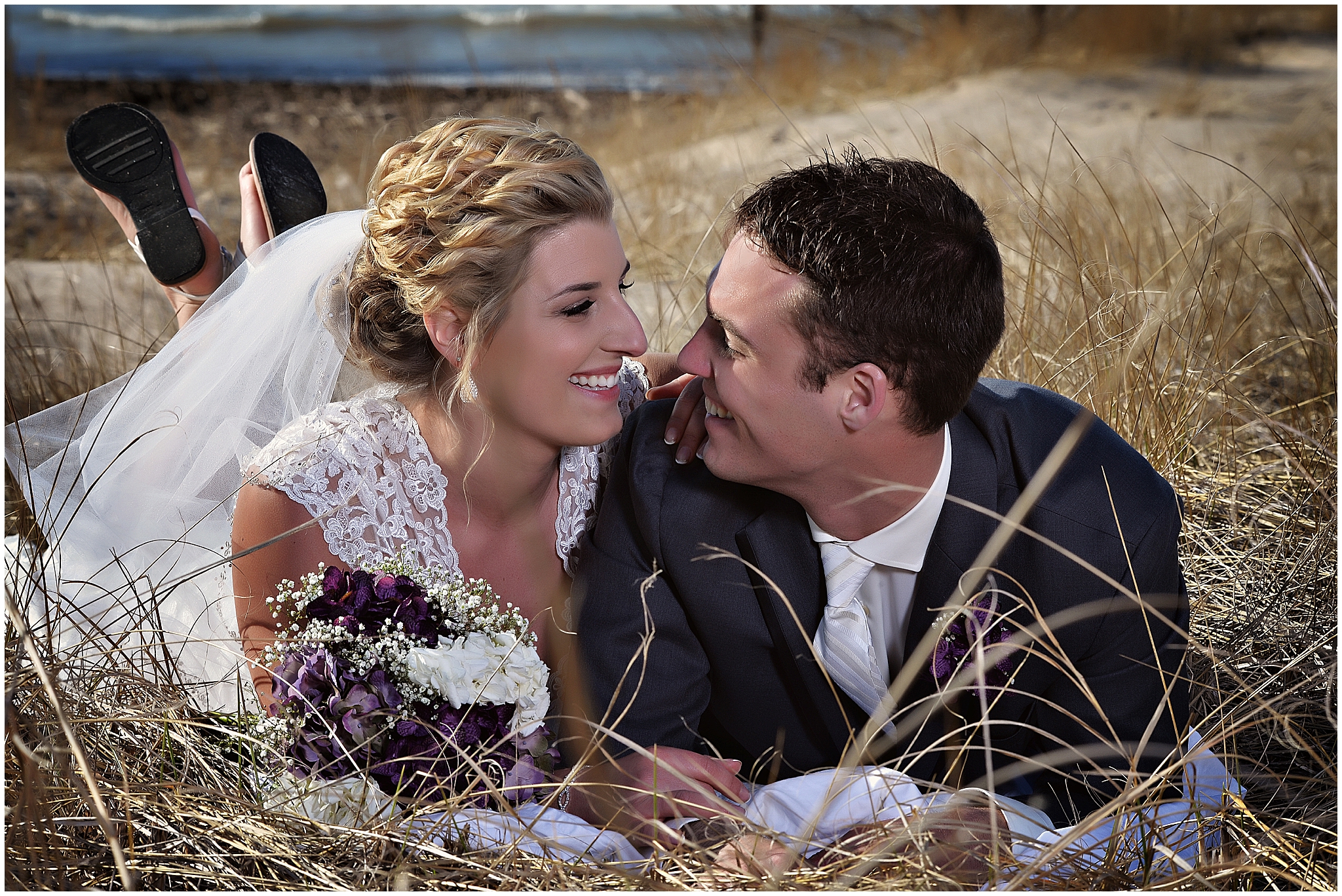 bride and groom laying on ipperwash beach