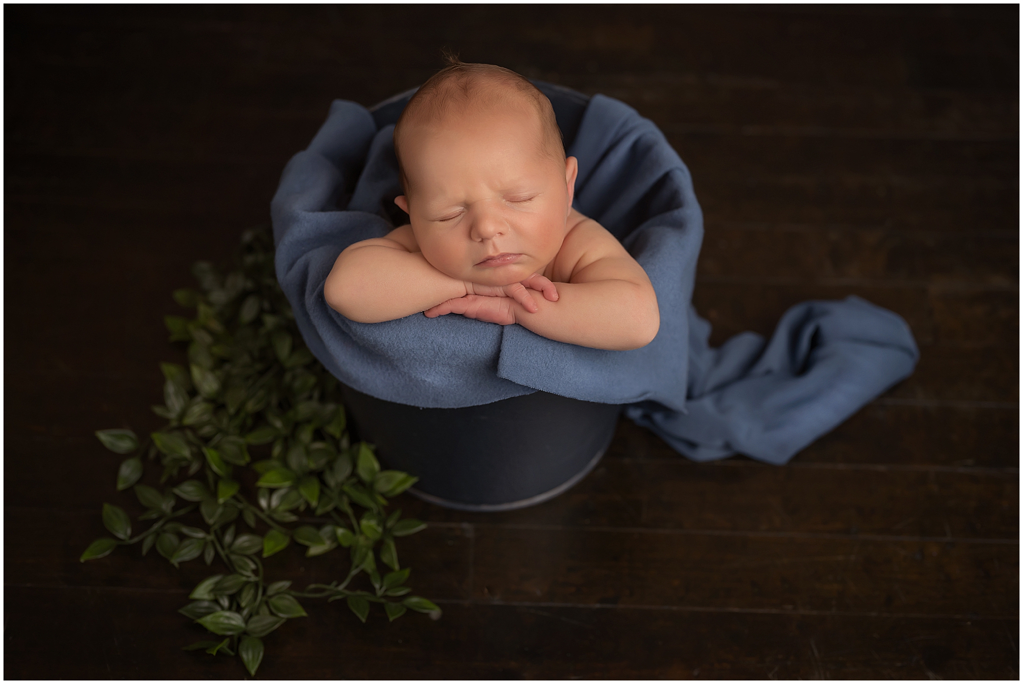 baby boy in bucket during newborn photography session in london ontario