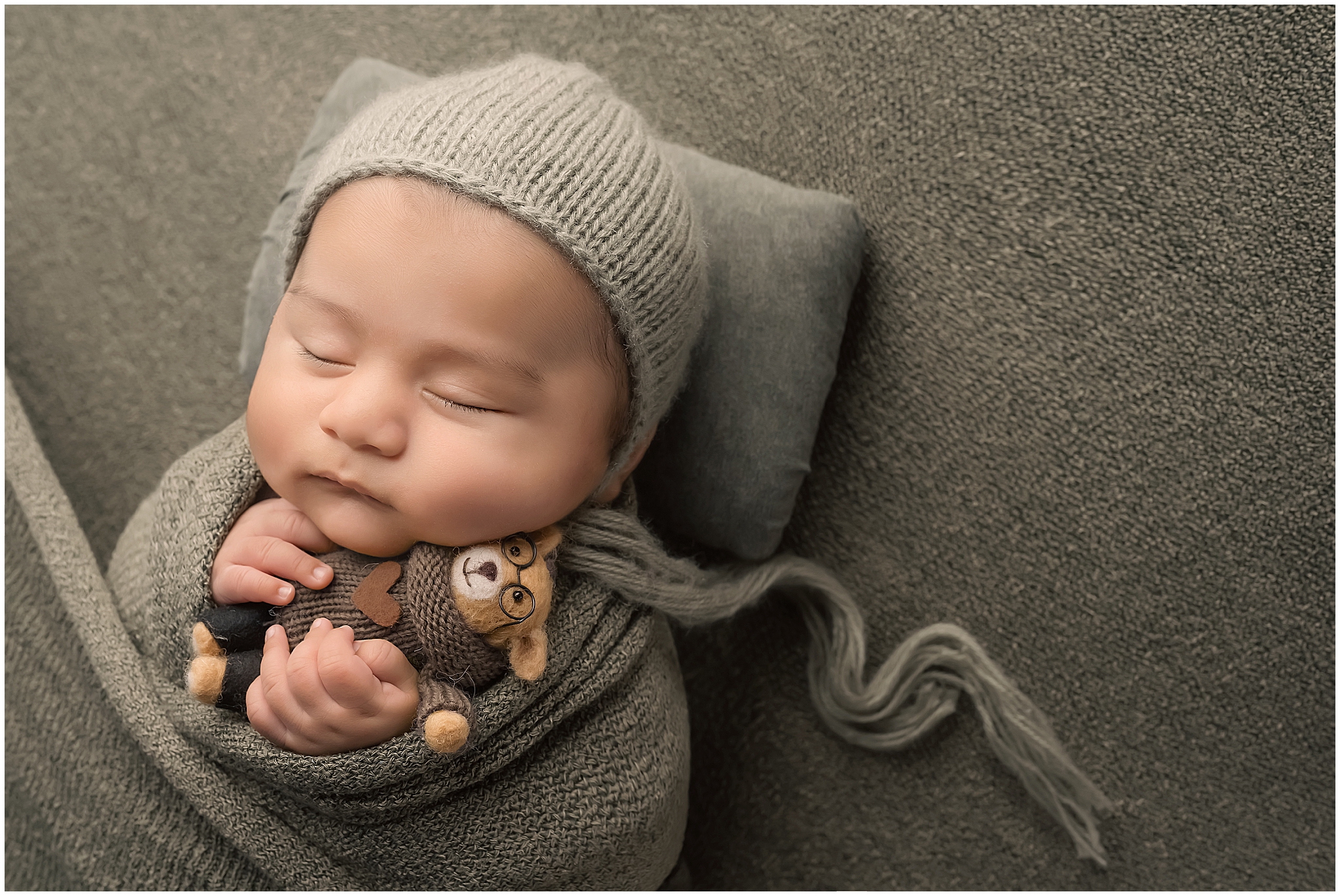 baby holding bear during newborn photography session in london ontario