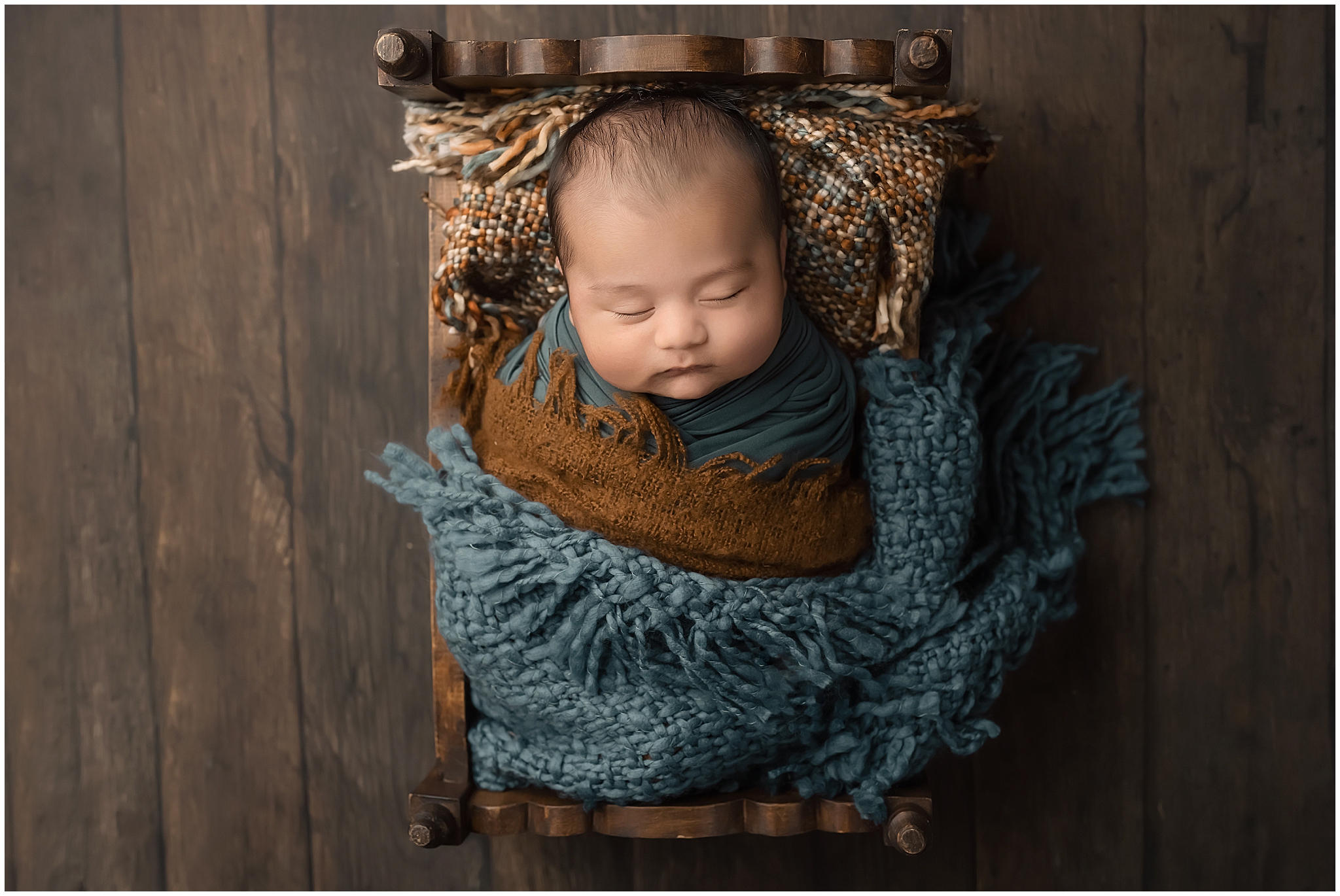 baby sleeping in tiny bed during newborn photography session in studio in london ontario