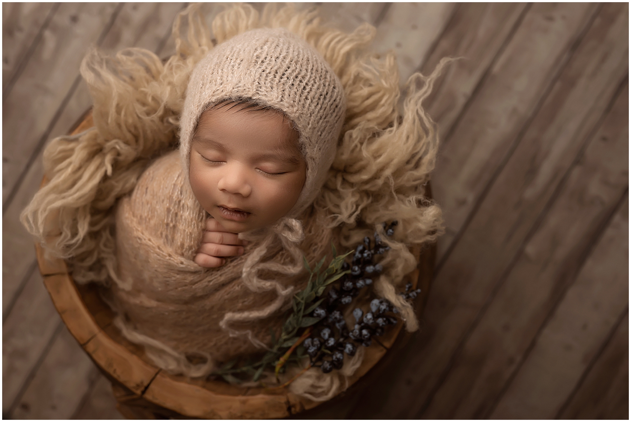newborn baby posing in bucket at photography studio in london ontario