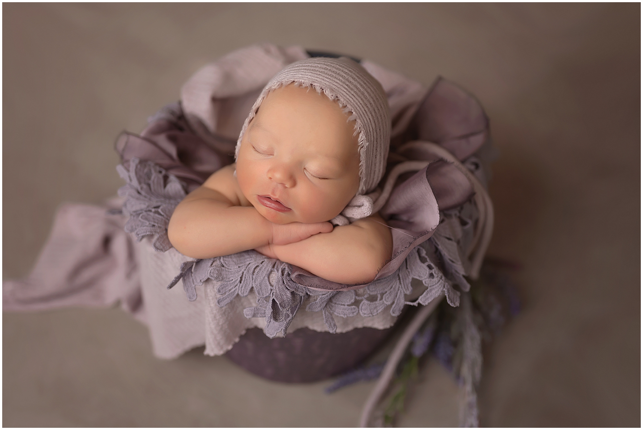 newborn baby posing in bucket during photography session in london ontario