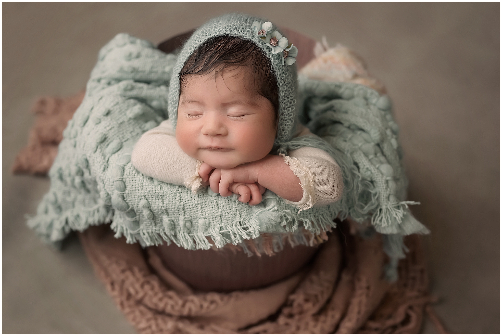 baby posing in bucket during newborn photography session in london ontario