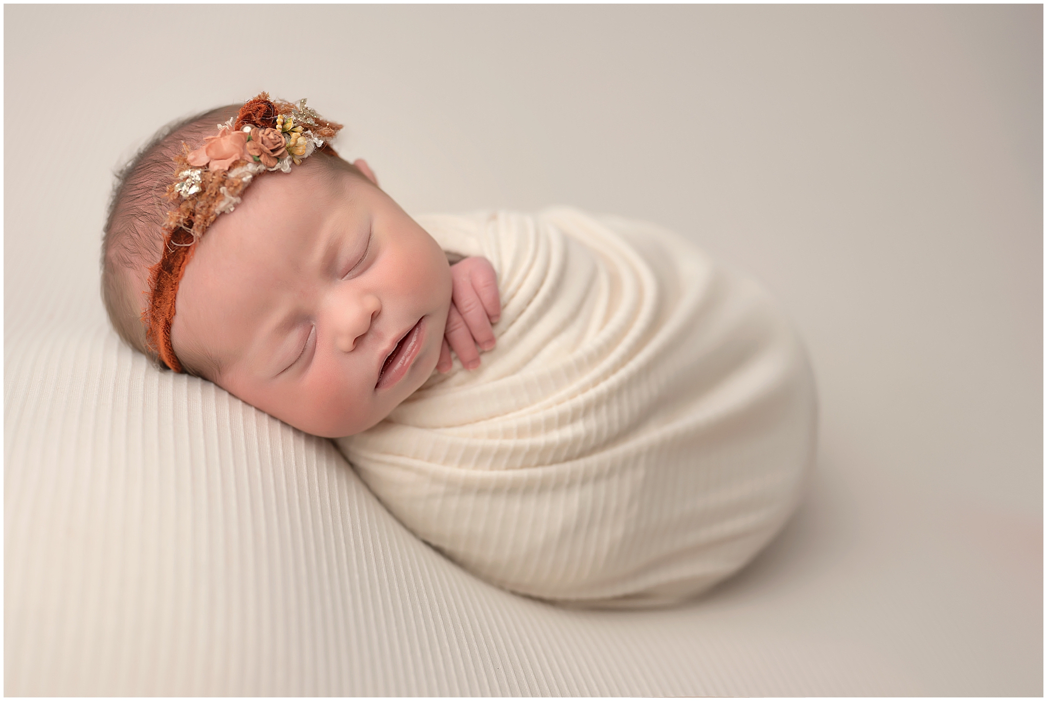 baby girl wrapped and sleeping during newborn session at photography studio in london ontario