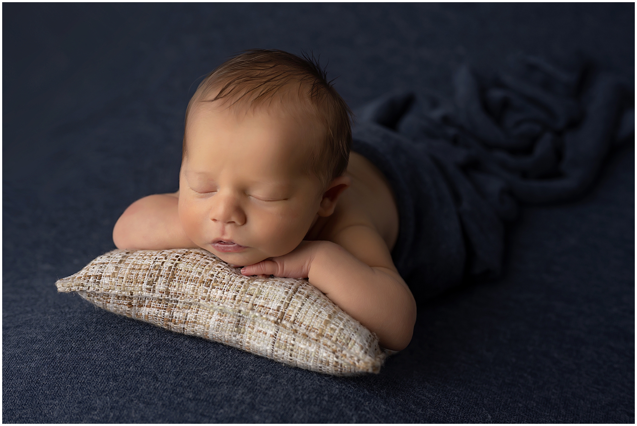 newborn baby posing on pillow during newborn photography session in london ontario