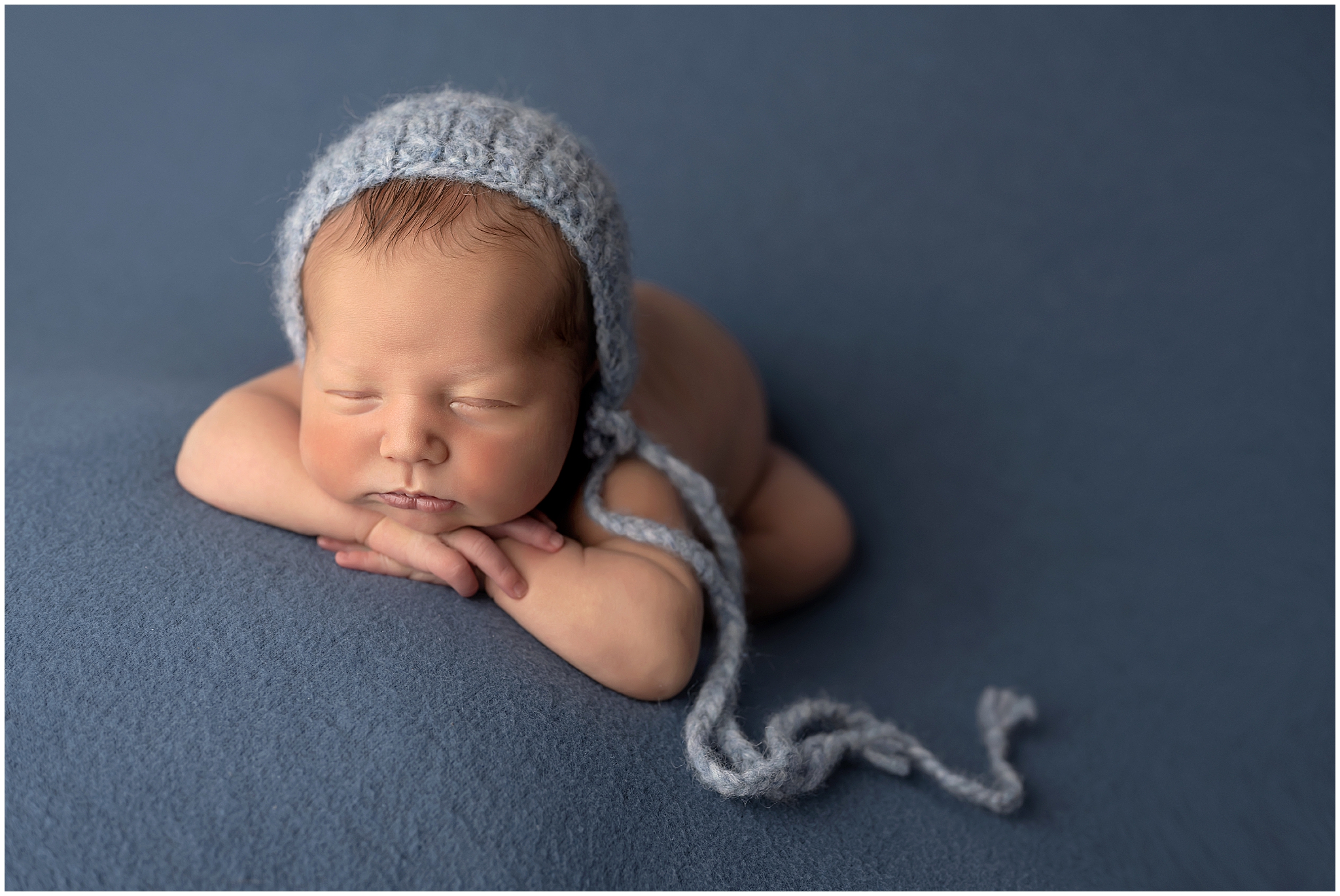 baby posing head on hands during newborn photography session in london ontario