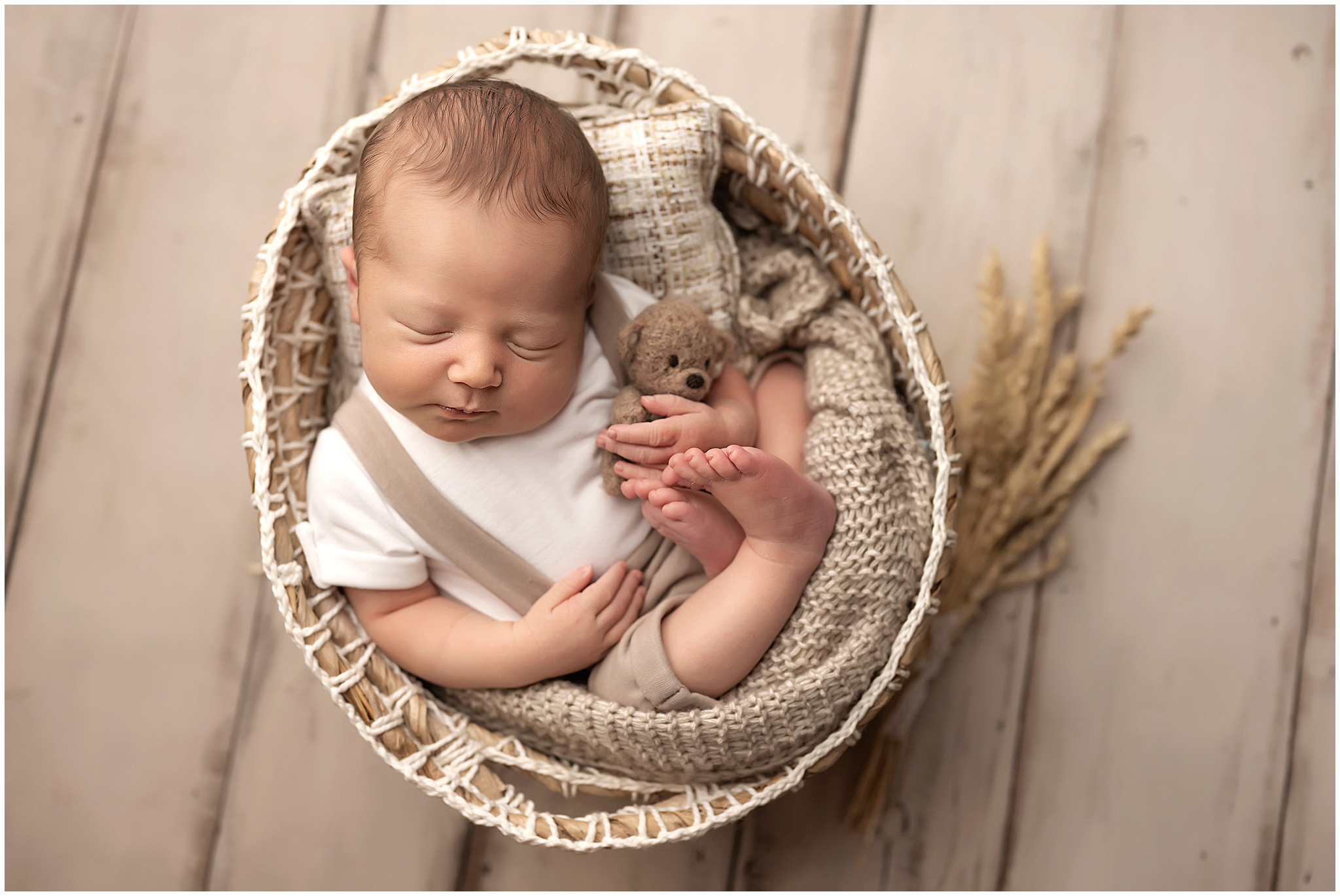 baby boy curled up in basket during newborn session at studio in london, ontario