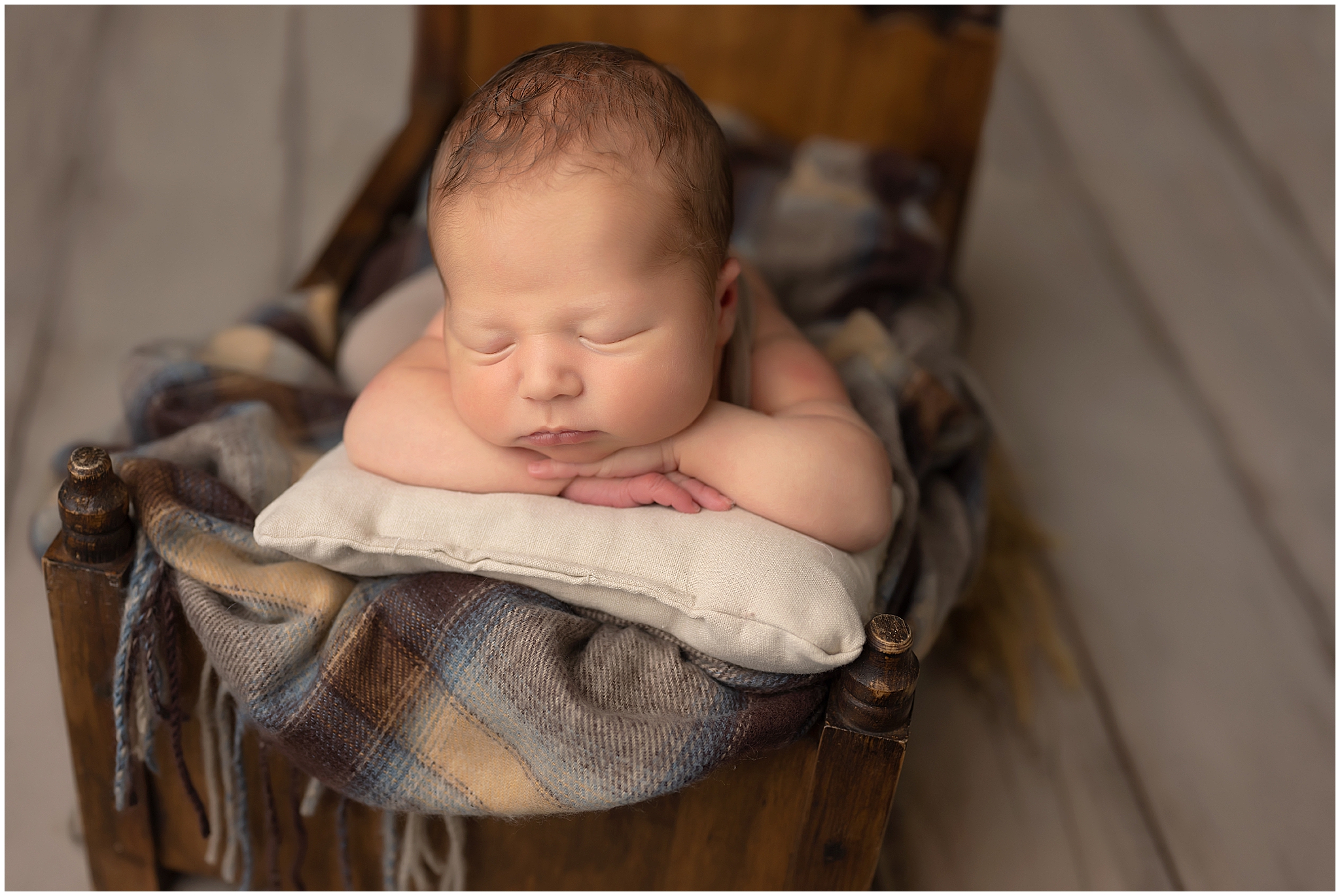 baby boy sleeping in tiny bed during newborn session at studio in london, ontario