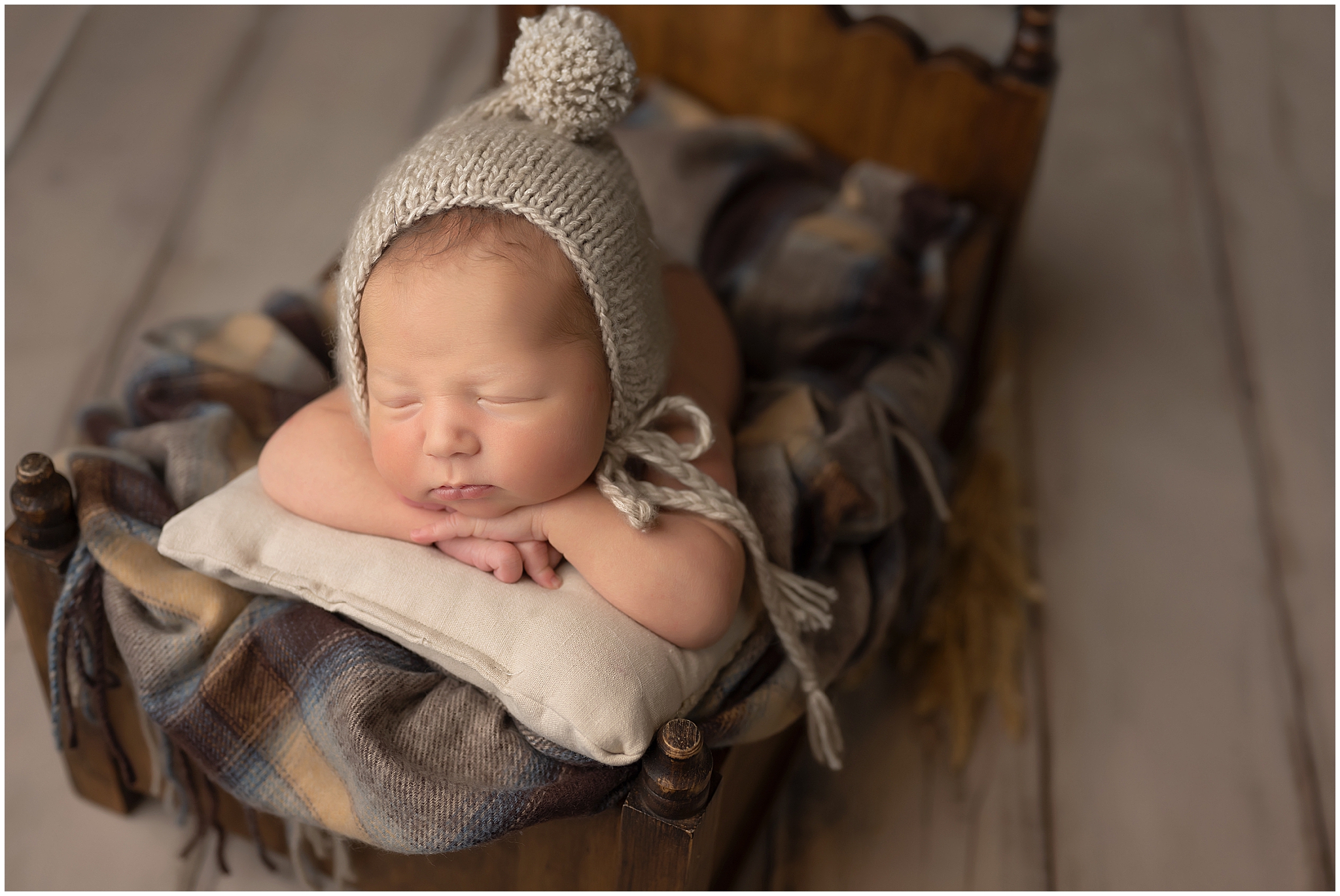 baby boy sleeping on tiny bed during newborn session at studio in london, ontario