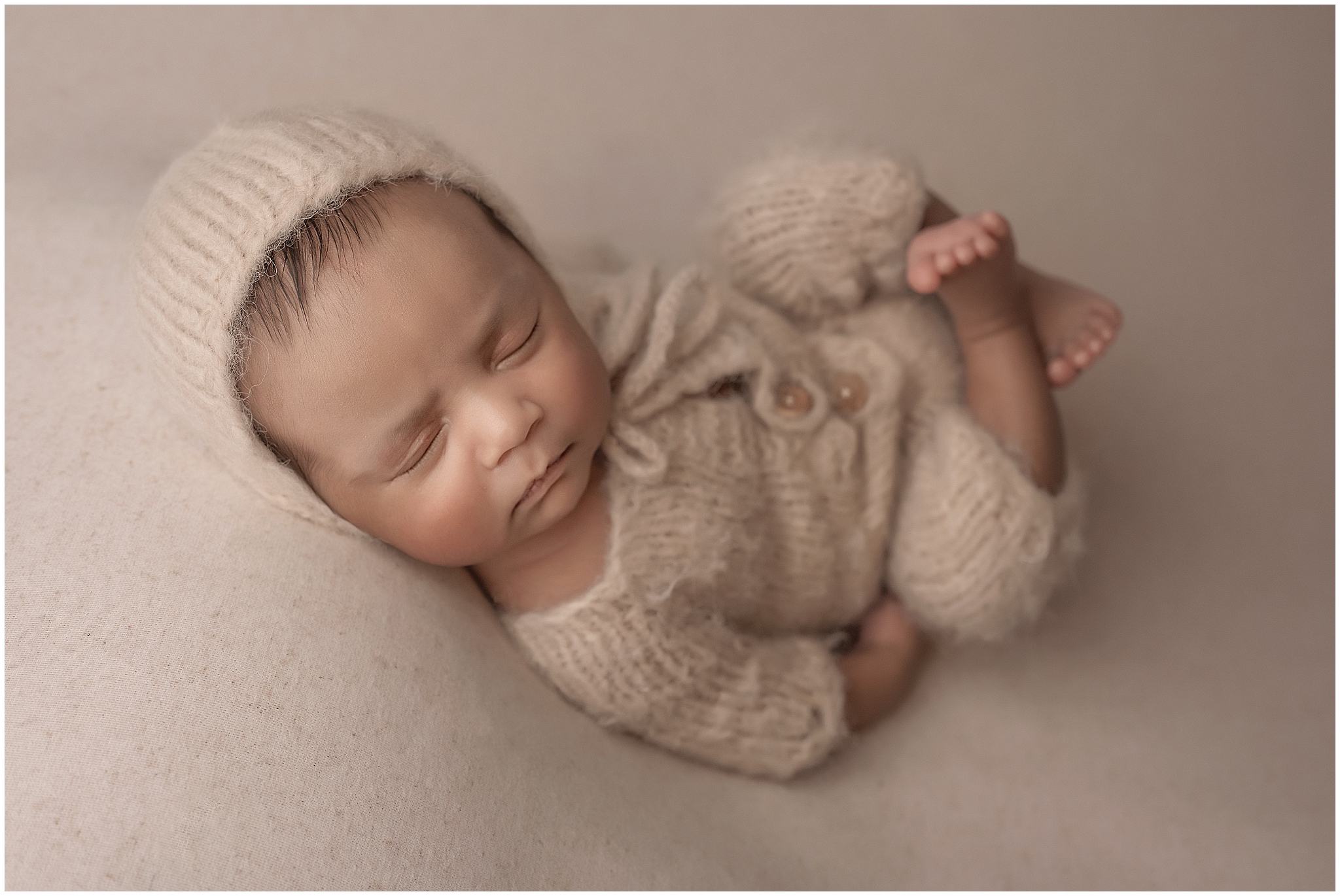 baby laying down and posing during newborn photography session at london ontario studio