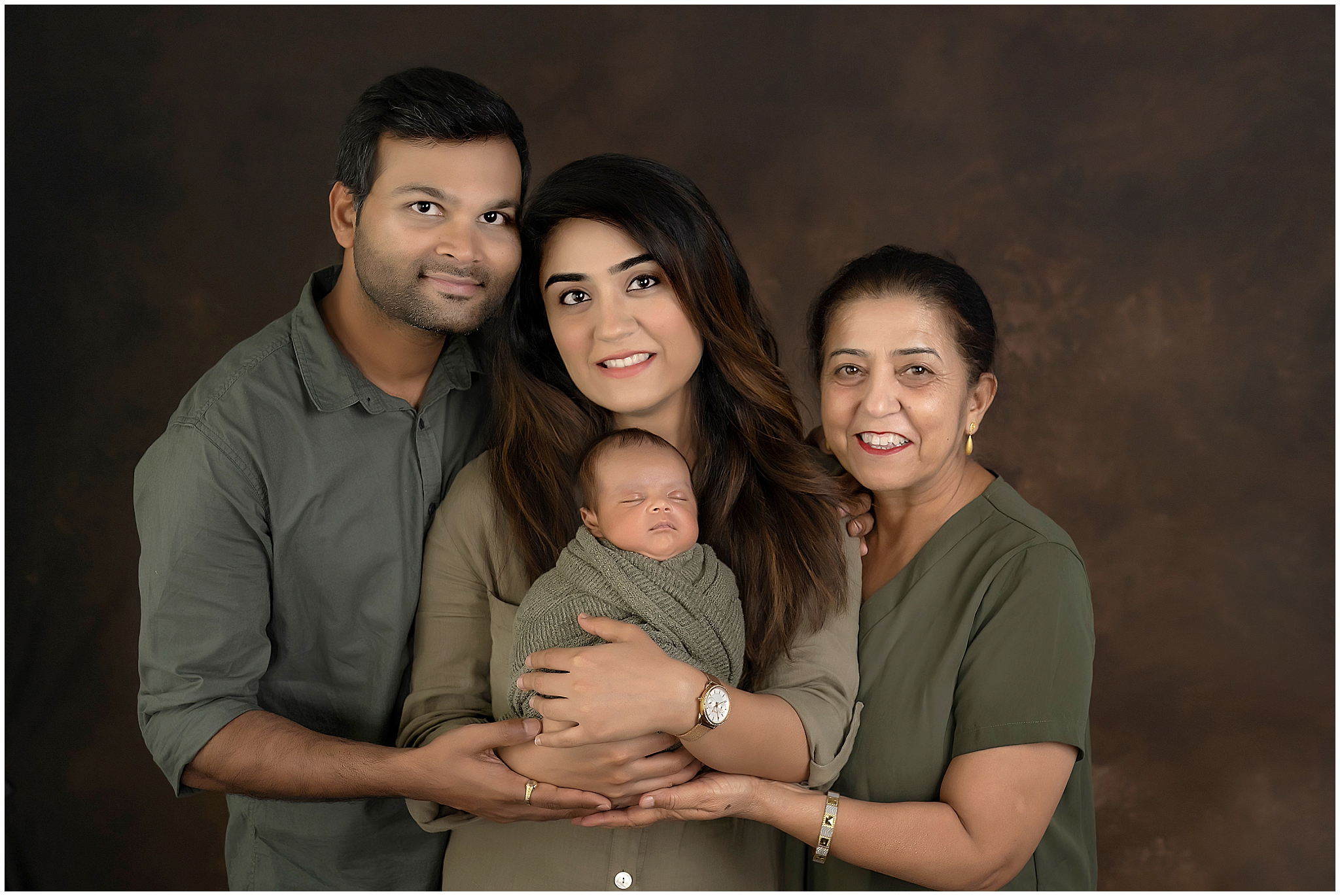 family posing with newborn baby  during newborn photography session at london ontario studio