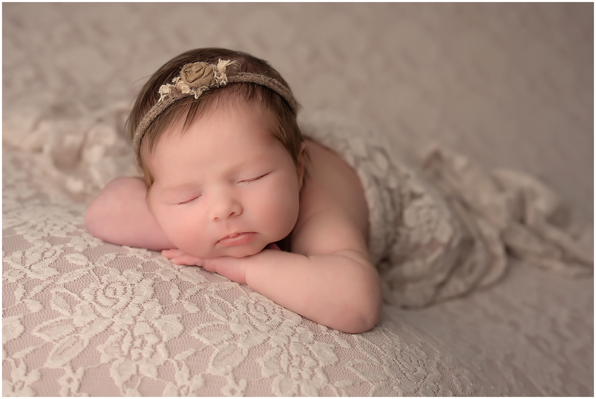 Newnorn baby girl sleeping on a lace blanket during newborn session at studio in London ontario