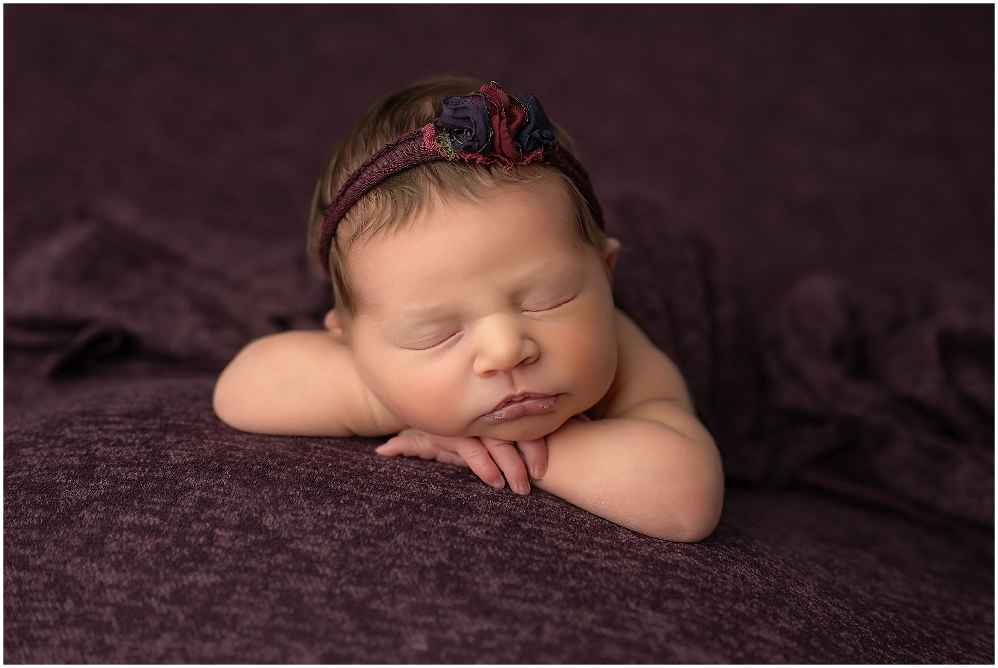 newborn baby girl sleeping with head on hands during session at london photography session