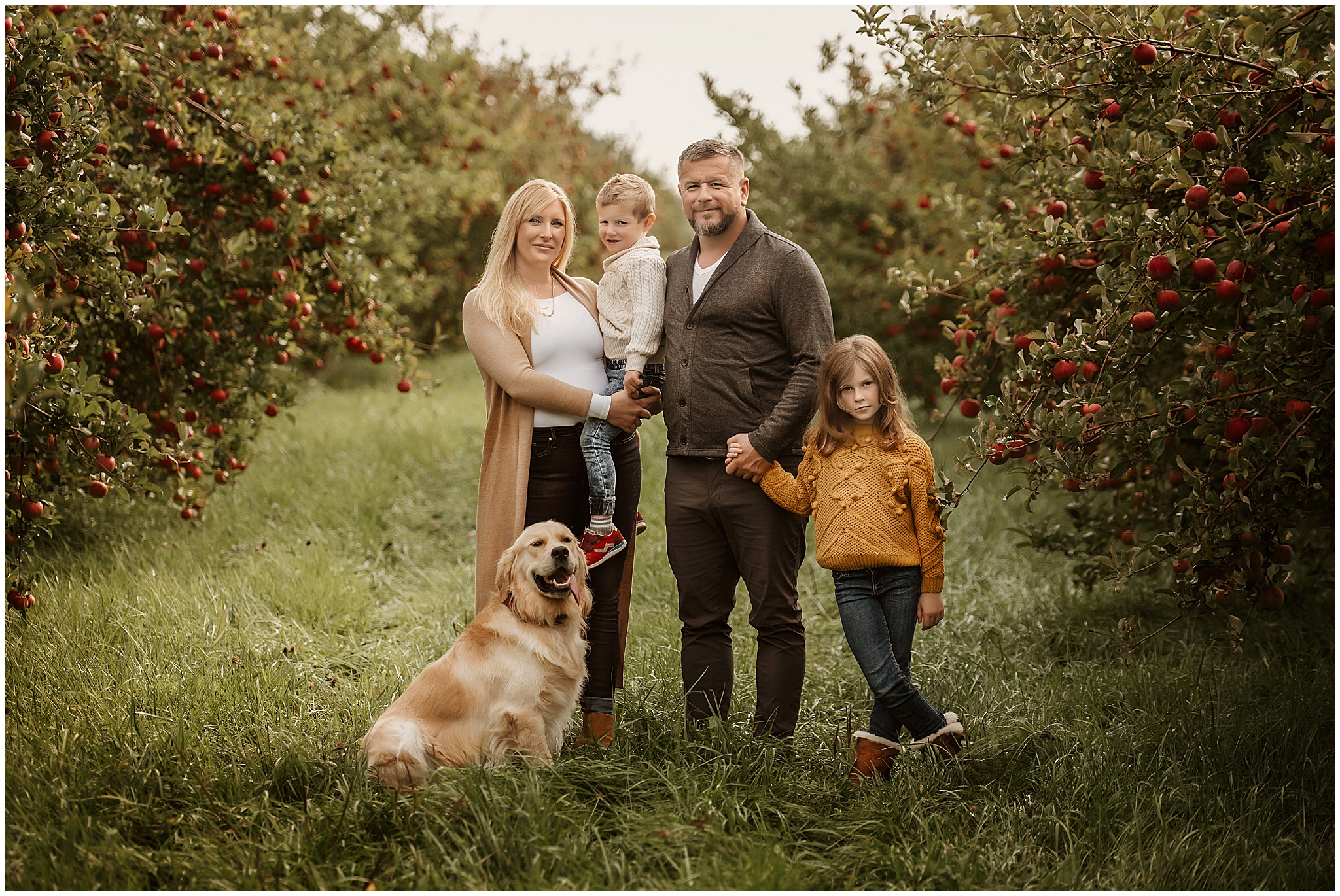 family posing in apple orchard for photographer near exeter ontario