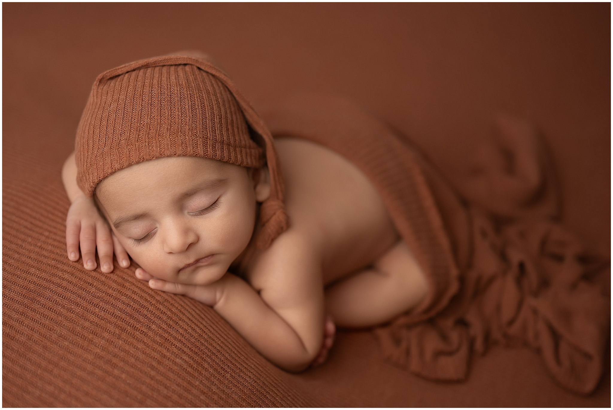 baby boy sleeping with head on hands during newborn photography session in london ontario