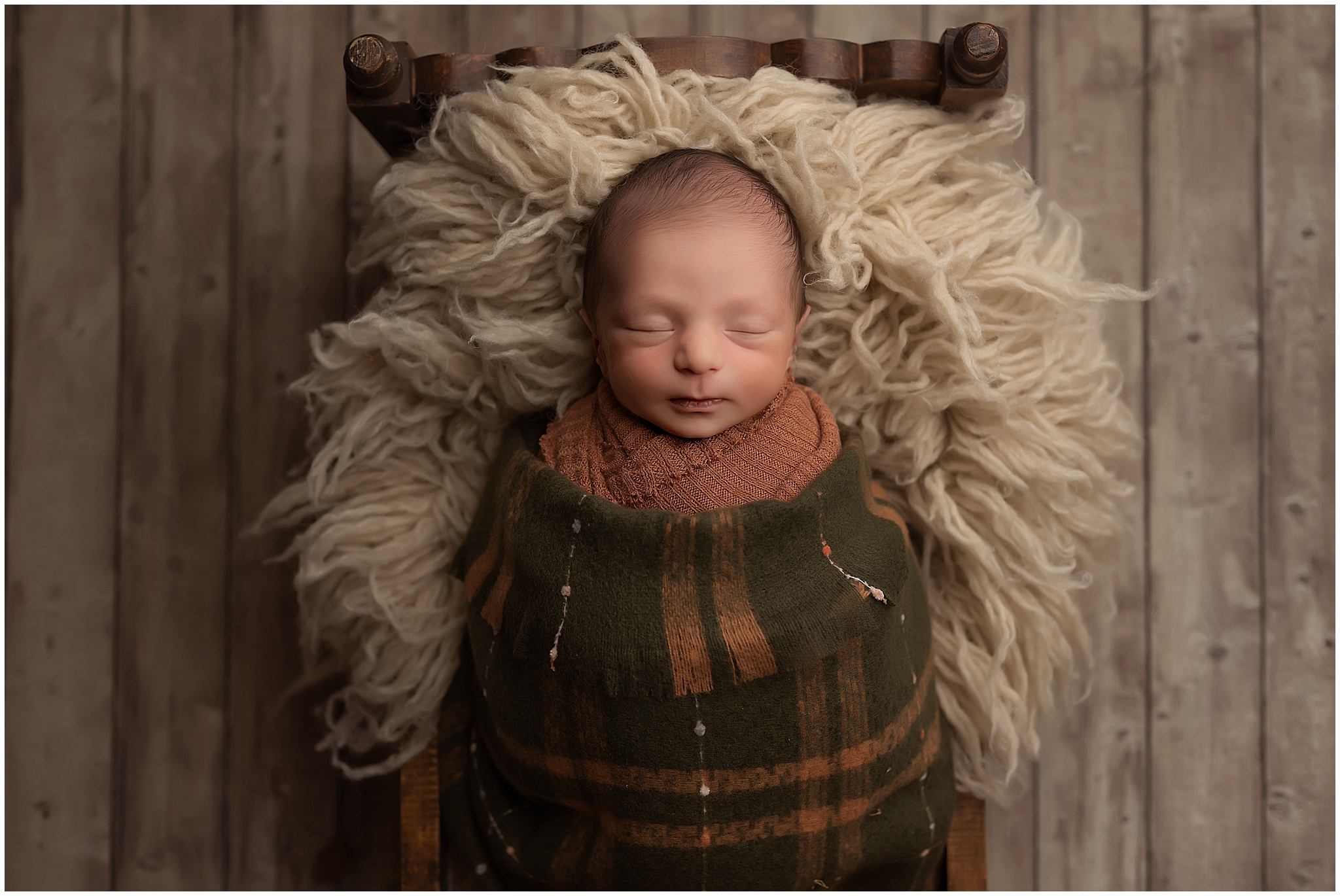 newborn baby boy sleeping in tiny bed during photography session in london ontario
