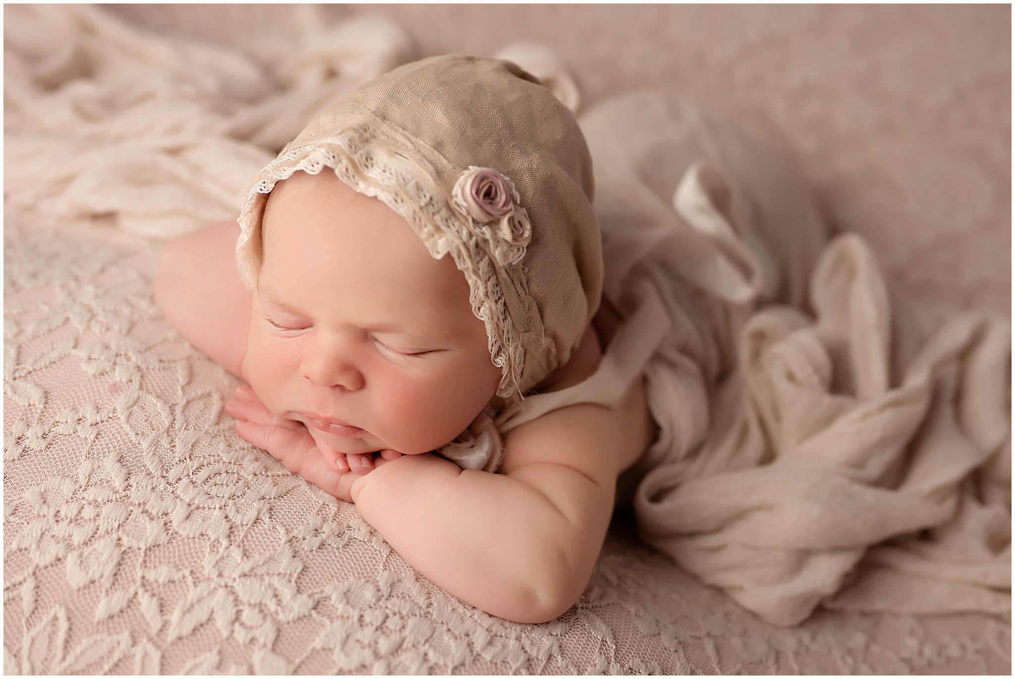 head on hands pose baby sleeping on pastel pink during newborn photography session in london ontario