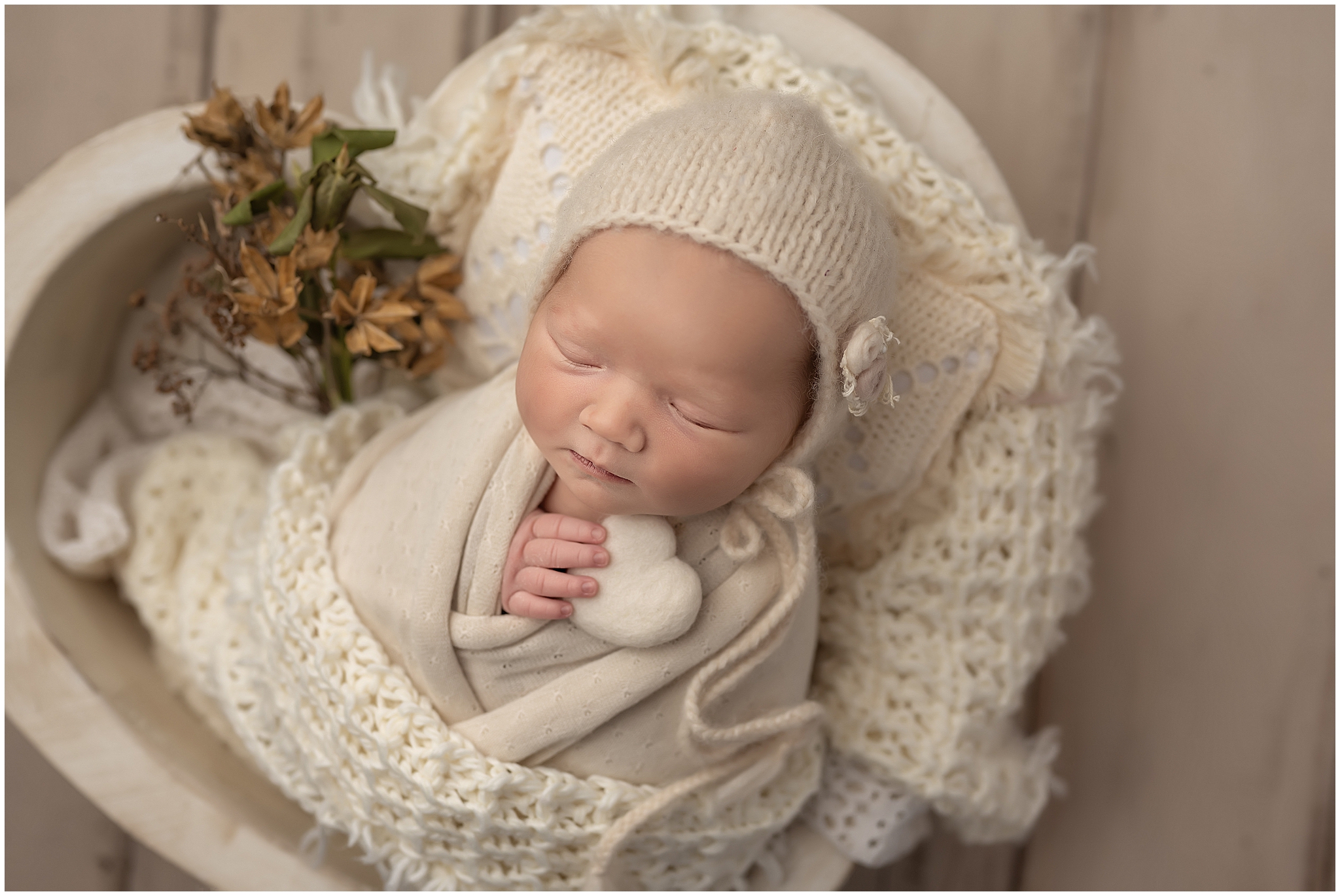 newborn baby sleeping in heart shaped bowl during newborn session in london ontario