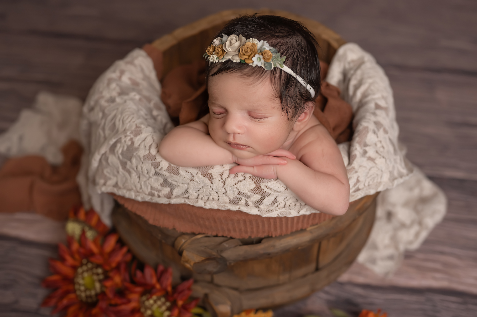 newborn baby girl sleeping  in wooden bucket during photography session in london ontario