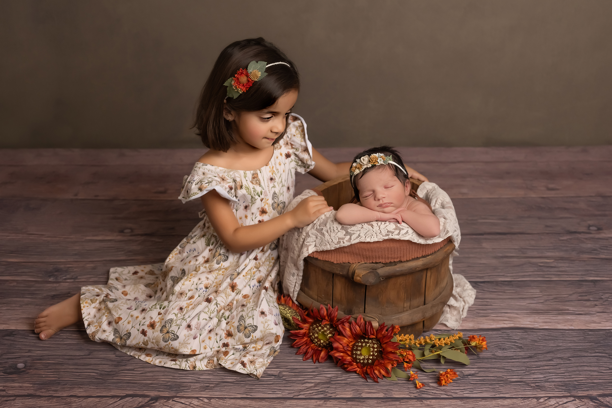 big sister posing with baby during newborn photography session in london ontario