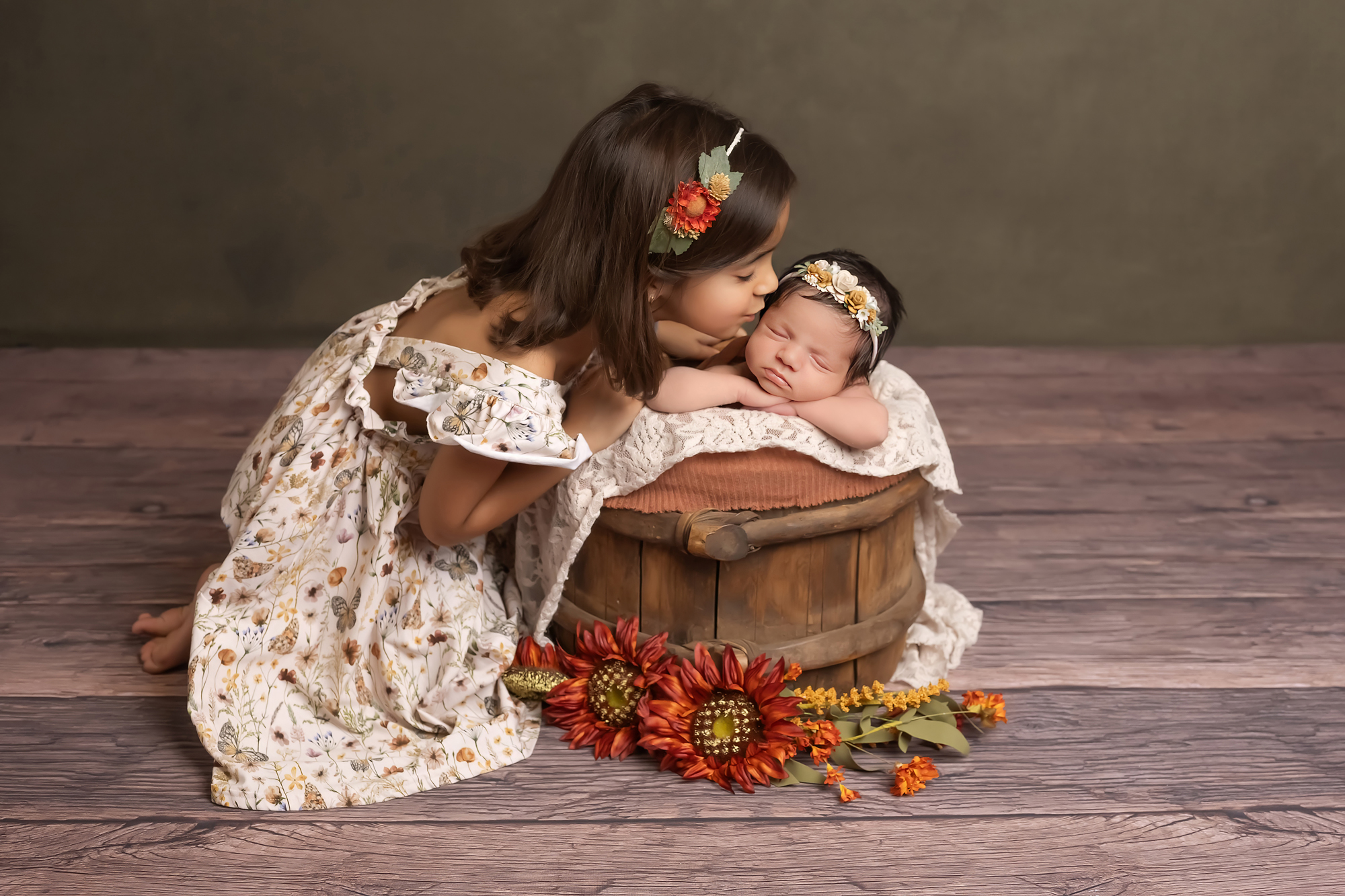 big sister kissing newborn baby girl during newborn session in london ontario