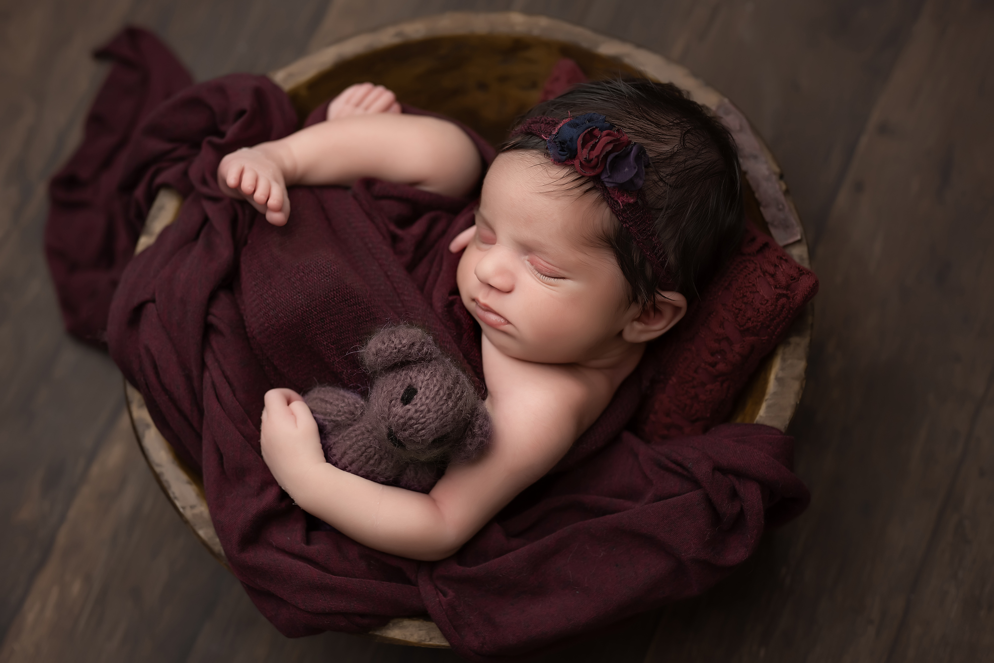 baby girl sleeping in a bowl with teddy bear during newborn photography session in london ontario