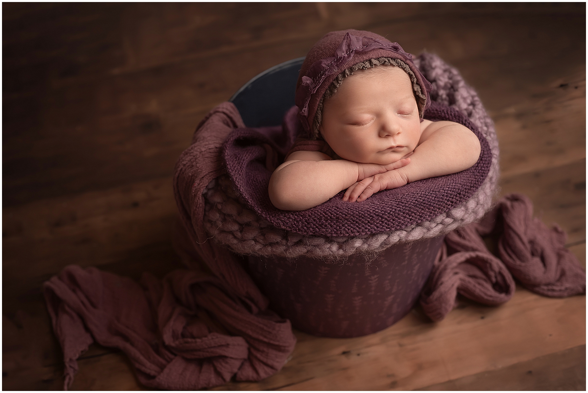 baby posing in a bucket during photography session